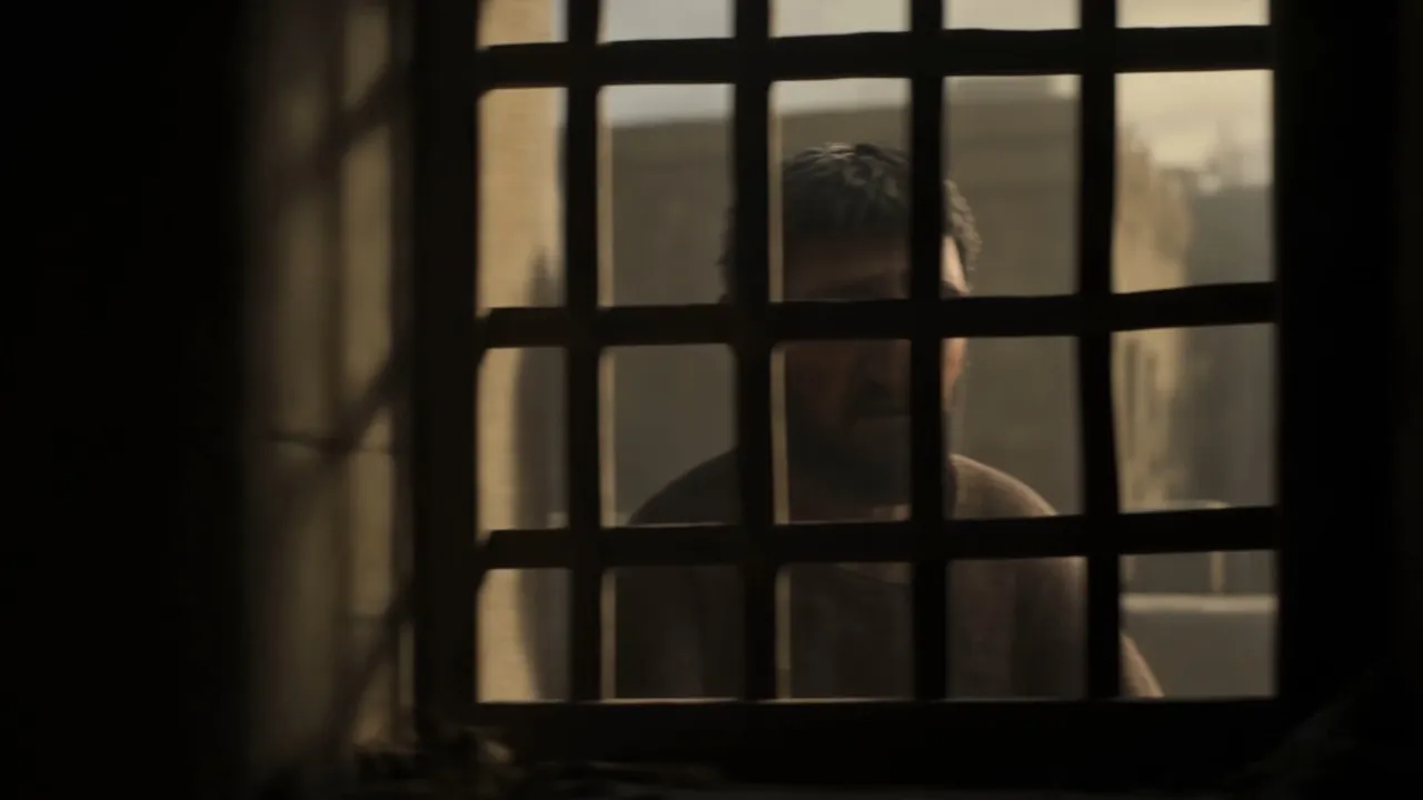 A face behind the bars, watching nothing happen