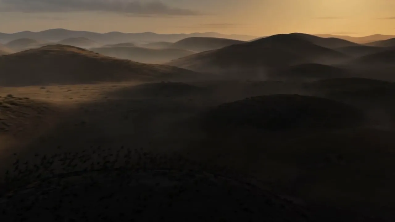 Its shadow rolls out over the hills, birds fleeing before the edge of it
